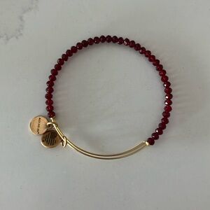 Alex and Ani gold bracelet with red beads.